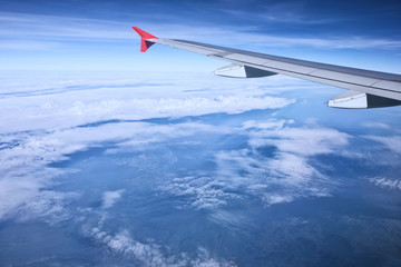 aerial view of passenger plane flying over beautiful blue sky and white cloudA