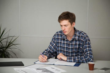 entrepreneur in casual clothes sitting at a table, studying documents