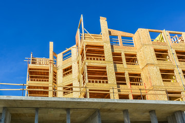 New low-rise building up on concrete base of first level on sunny day in British Columbia, Canada