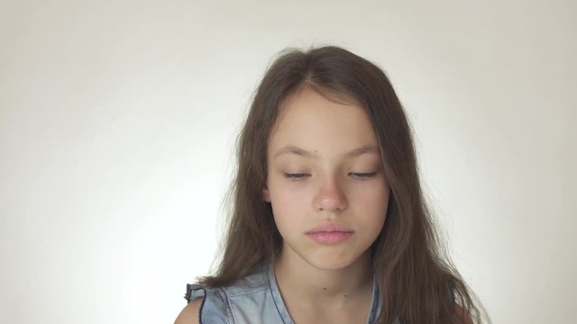 Beautiful sad teenage girl emotionally expresses resentment close-up on white background stock footage video
