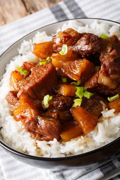 Philippine spicy pork Hamonado with pineapple and rice close-up. vertical