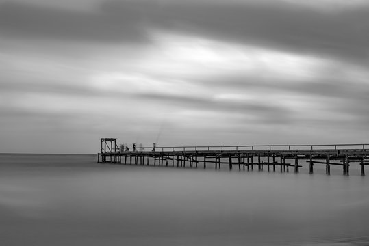 a bridge with fishermen in the sea, Atlit, Israel. Black and white photo