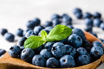 Organic blueberries on spoon, superfood concept with berries isolated on white background