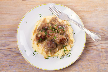 Meatballs with mushroom gravy and mashed potato on white plate. View from above, top studio shot, horizontal