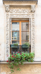Fototapeta na wymiar Paris, typical window with sculptures carved around 