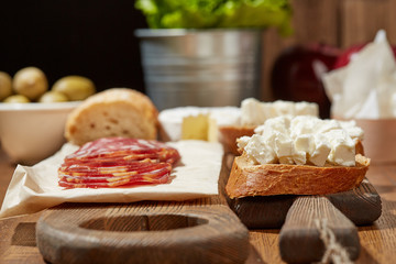 Cheese, vegetables, fruits and spices. Bread, olives and crackers. Mediterranean diet and cuisine. Dark background.