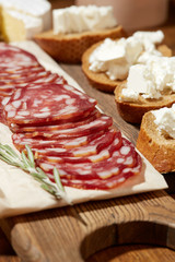 Cheese, vegetables, fruits and spices. Bread, olives and crackers. Mediterranean diet and cuisine. Dark background. Top view.