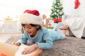 small child writes the letter to Santa