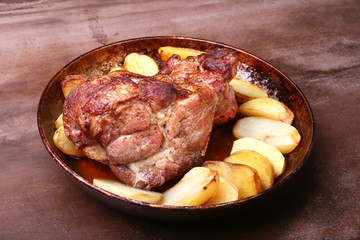 Juicy pork neck chops are grilled with potatoes on a stone Background.