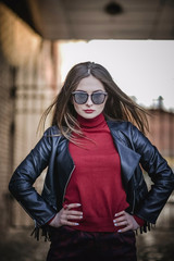 the coolest girl in the black leather jacket and sunglasses, walks through the city