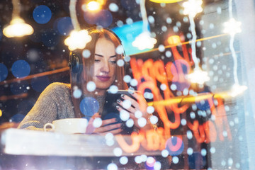Fototapeta na wymiar Young beautiful woman sitting in cafe, drinking coffee. Model listening to music. Christmas, Happy new year, Valentines day, winter holidays concept
