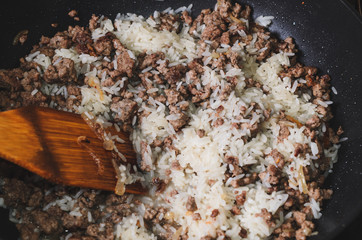 Minced meat with rice and vegetables in a frying pan. Close up