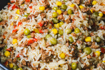 Minced meat with rice and vegetables in a frying pan. Close up
