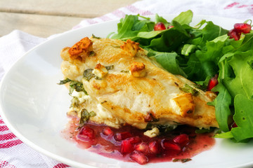 fried chicken breast fillet gratinated with feta cheese, pomegranate sauce and arugula salad, soft focus