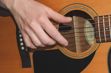 Musician playing acoustic guitar, close up