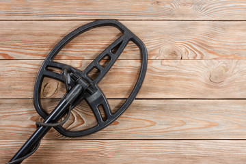 Metal detector on old rustic wooden table.