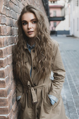 brunette standing nearby brick wall outside