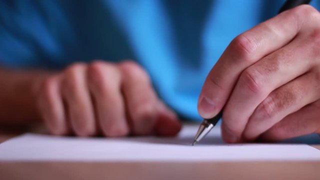 Man writing a letter by left hand and crumpling a paper