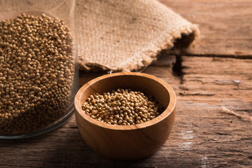 Coriander seeds on a wood background