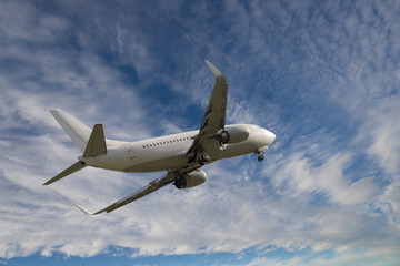 Naklejka na ściany i meble Airplane flying in sky with clouds