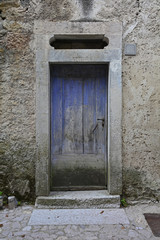 Fototapeta na wymiar An old wooden door in a derelict building the historic hill village of Erto in Friuli Venezia Giulia, north east Italy 