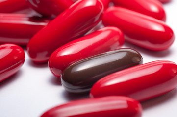 Red pills capsules on white background