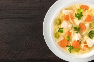 Chicken soup with noodles, overhead closeup photo with copyspace