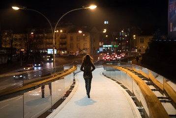 woman going late night on the pedestrian bridge - Powered by Adobe