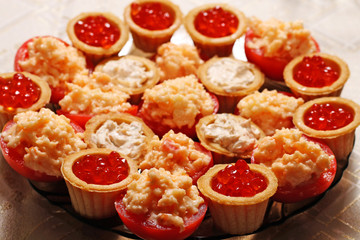 Fototapeta na wymiar Tartlets with red caviar and cheese served on a festive table