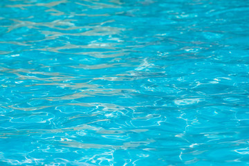 Blue and bright water surface and ripple wave with sun reflection in swimming pool