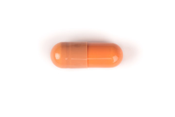 close-up of a brown pill from above isolated on a white background.psd