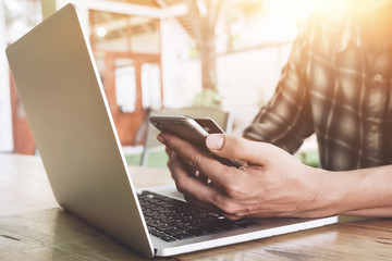 Online payment, Man's hands holding a credit card and using laptop computer for online shopping at cafe coffee shop with vintage filter tone