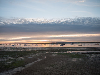 sun set sky dramatic clouds sea front beach harbor marina boats moored landscape