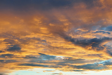 Naklejka na ściany i meble Blue bright evening morning sky with dramatic colorful yellow orange clouds.