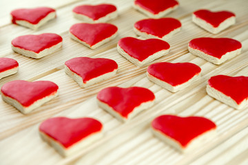 rote weihnachtliche Plätzchen in herzform liegen auf Holz