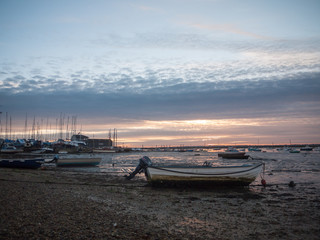 sun set sky dramatic clouds sea front beach harbor marina boats moored landscape