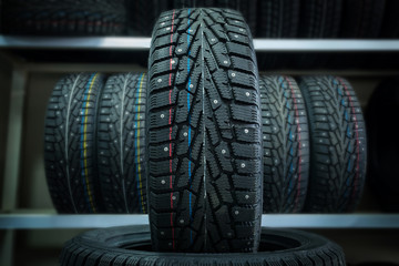 Winter tire on the background of racks with tires