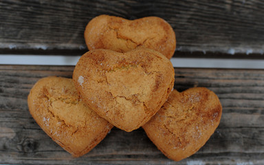 Homemade cookies with sugar and cinnamon in the form of hearts on a wooden background