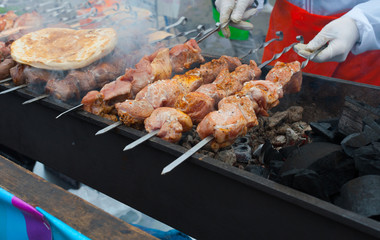 Pieces of meat on skewers are roasted on hot coals.
