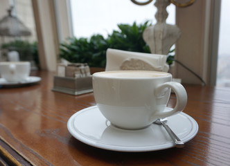 Hot coffee in white coffee cup on timber table