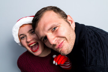 Christmas New Year happy couple celebrate holiday emotions man and woman in Santa Claus hats