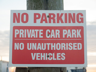 no parking private car park no authorized vehicles sign on post close up