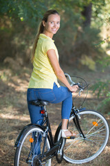 Naklejka premium young woman biking in the forest