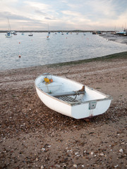 small white private boat parked moored on beach front bay