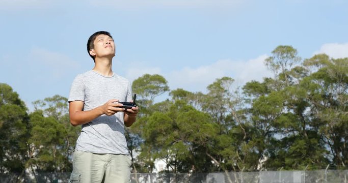 Asian Man control fly drone with blue sky
