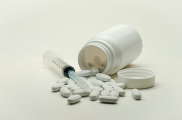 Pills, vitamins and syringe for injection with medications isolated on white background