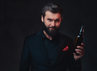 A man in a black suit presenting craft beer.