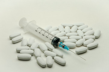 Pills, vitamins and syringe for injection with medications isolated on white background
