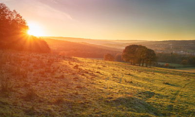 Red, Orange and yellow glow of a sunset over green pastures and trees in the English Countryside. Gibside  near Newcastle upon Tyne.