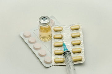 Pills, vitamins and syringe for injection with medications isolated on white background